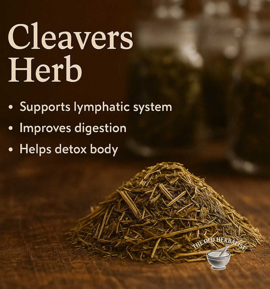 Heap of cleavers herb with benefits listed on a wooden surface, branded 'The Old Herbist'.