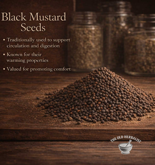 Black mustard seeds on a wooden surface with text about their uses and The Old Herbalist logo.