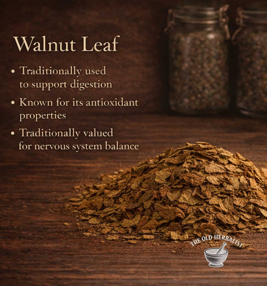 Walnut leaf on a wooden surface with text about its uses and The Old Herbalist logo.
