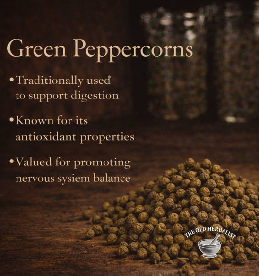 Green peppercorns with text about their uses on a wooden surface, branded 'The Old Herbalist'.