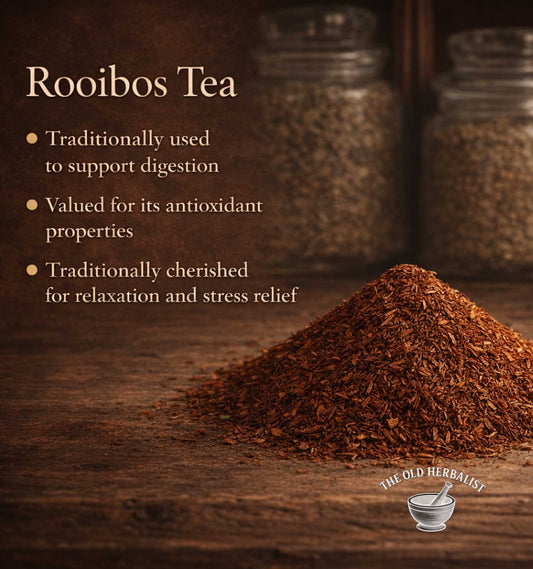 Rooibos tea leaves with text about its benefits on a wooden surface, featuring The Old Herbalist logo.