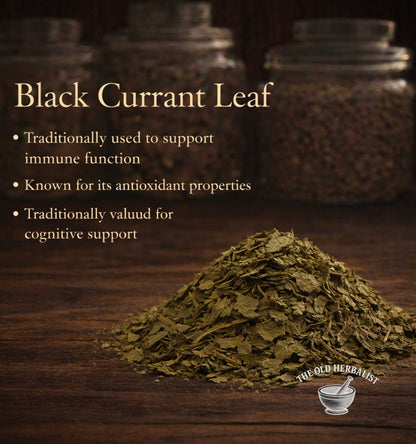 Heap of black currant leaf with text about its uses on a wooden surface, branded 'The Old Herbalist'.