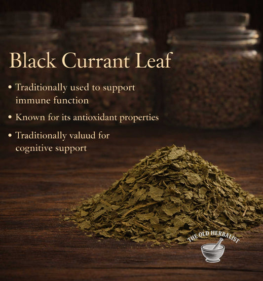 Heap of black currant leaf with text about its uses on a wooden surface, branded 'The Old Herbalist'.