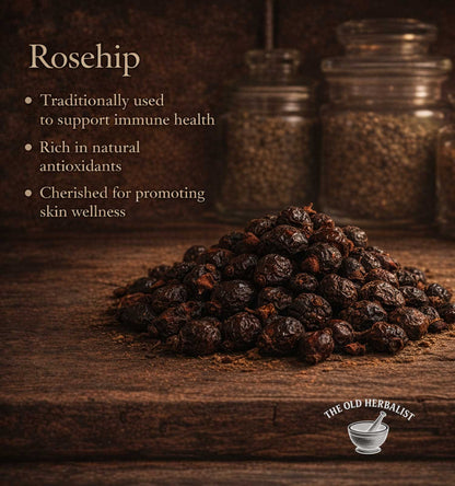 Rosehips on a wooden surface with text about their health benefits and The Old Herbalist logo.